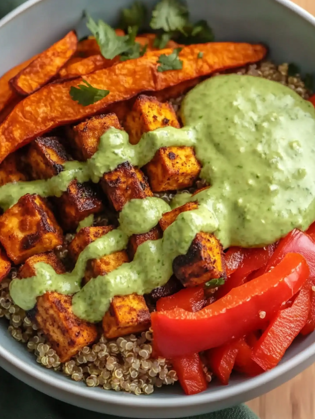 A bowl of food with tofu, vegetables and sauce.