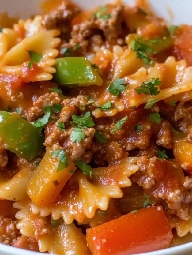 A close up of a bowl of pasta with meat and vegetables.