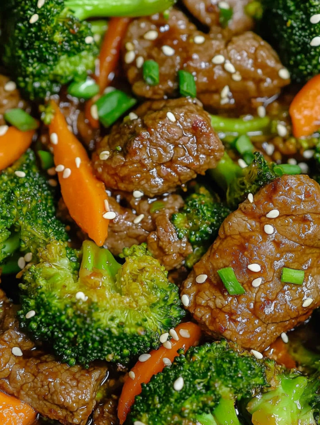 A plate of beef and broccoli with a variety of vegetables.