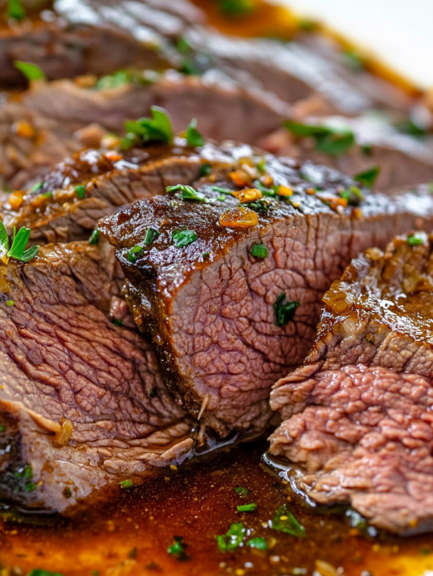 A close up of a piece of meat with herbs on it.