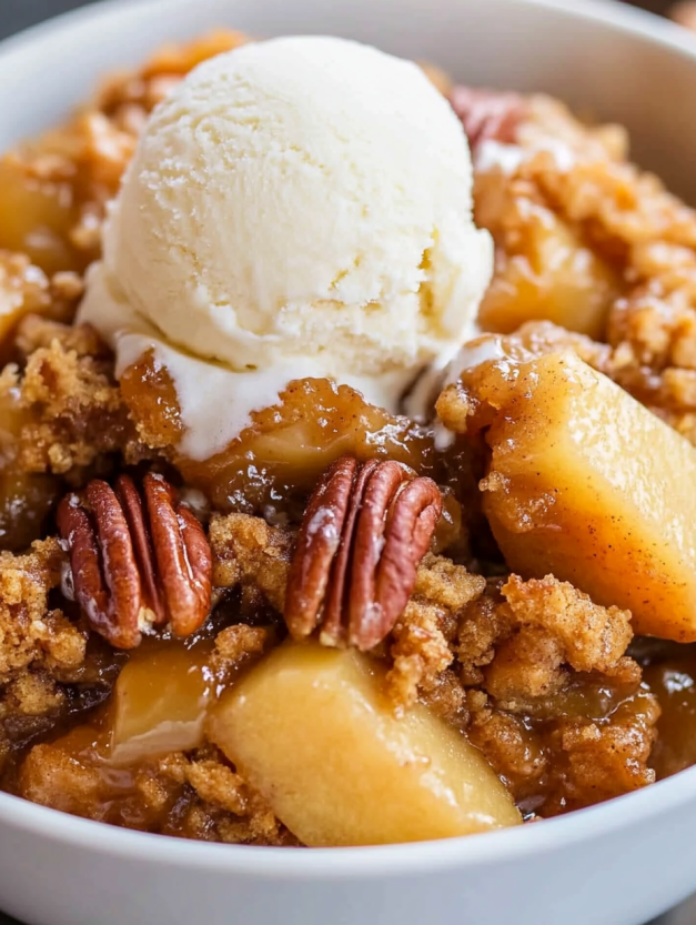 A bowl of apple dump cake with a scoop of ice cream on top.