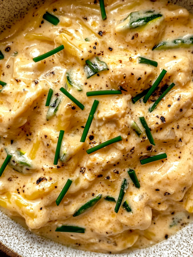 A bowl of creamy chicken soup with pasta.