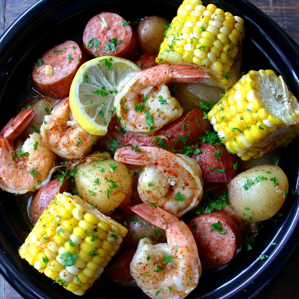 A bowl of shrimp, corn, and potatoes.