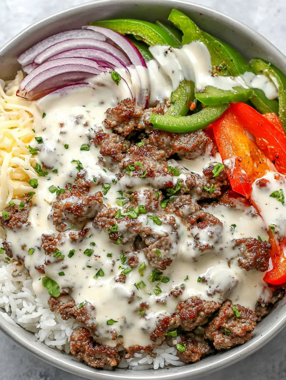 A bowl of food with meat, cheese, and vegetables.