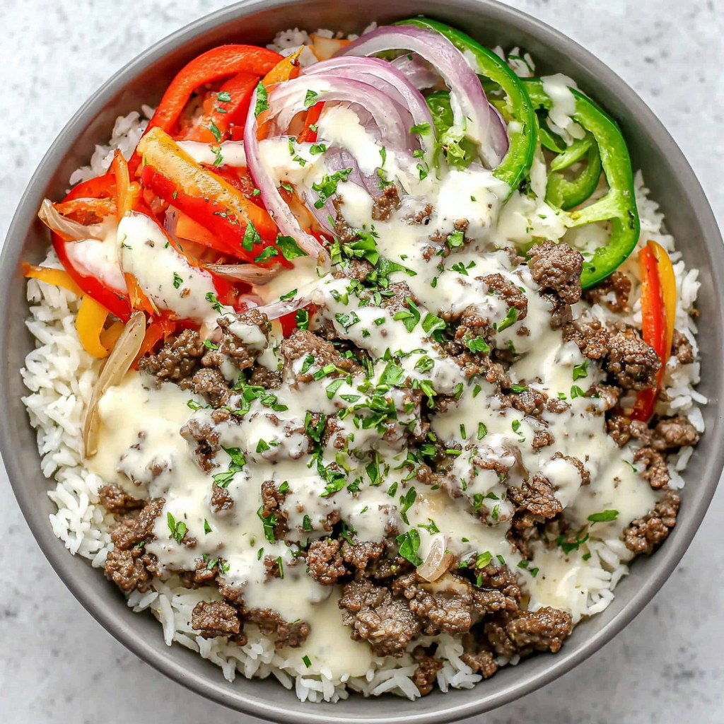 A bowl of food with rice, meat, and vegetables.