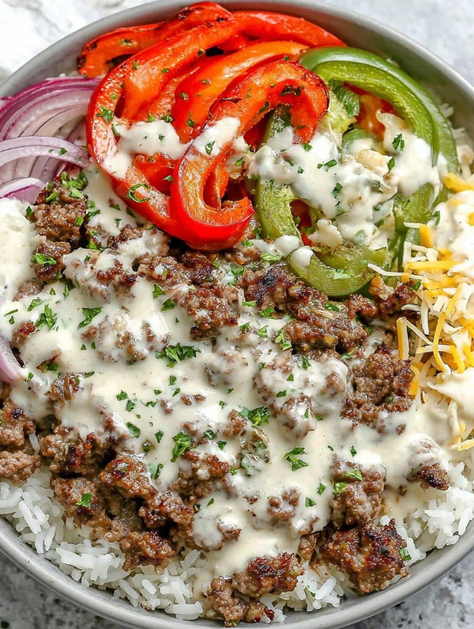 A bowl of food with meat, tomatoes, onions, and cheese.