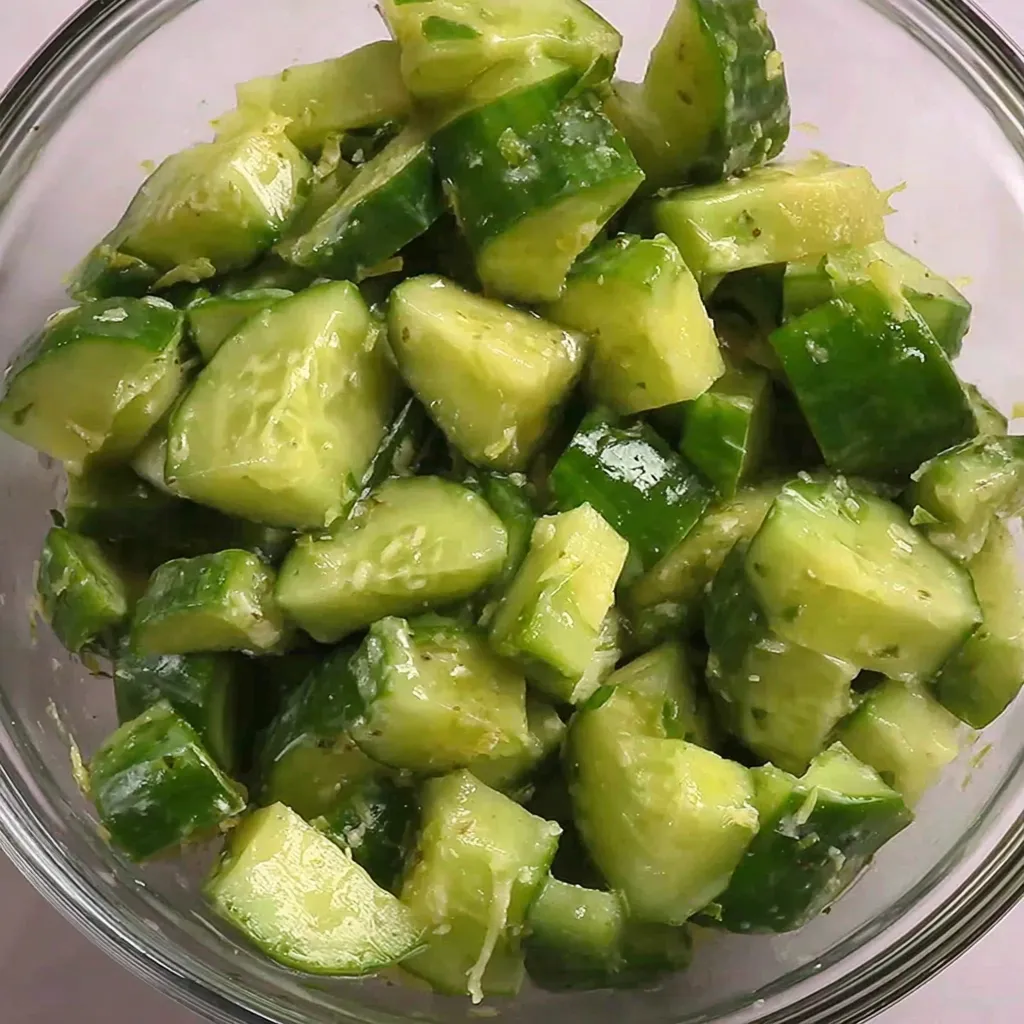 A bowl of cucumber salad with lemon and cumin.