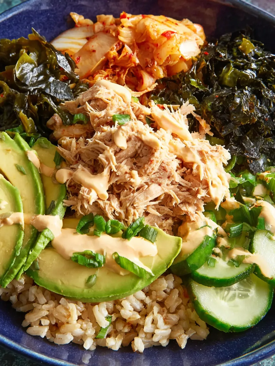 A rice bowl with canned tuna, avocado, and greens.