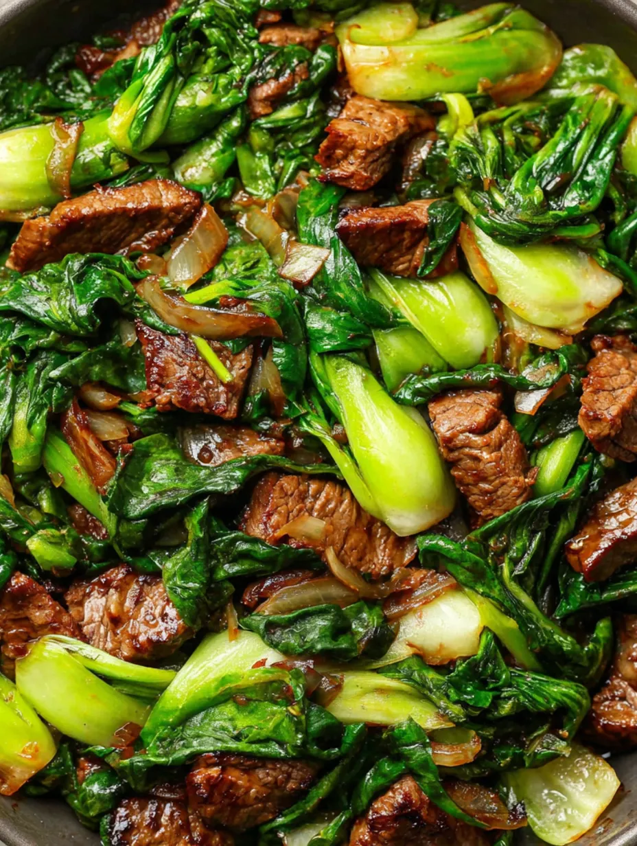A close up of a beef stir fry with baby bok choy and ginger.