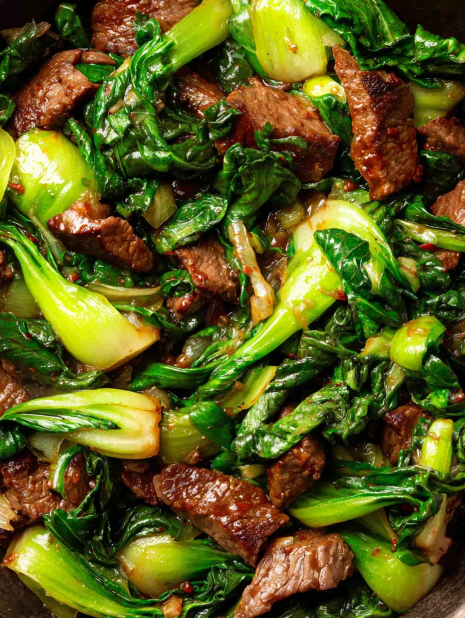 A close up of a beef stir fry with baby bok choy and ginger.