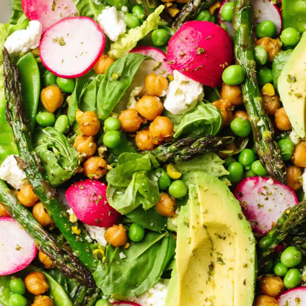A colorful salad with avocado, peas, and other vegetables.
