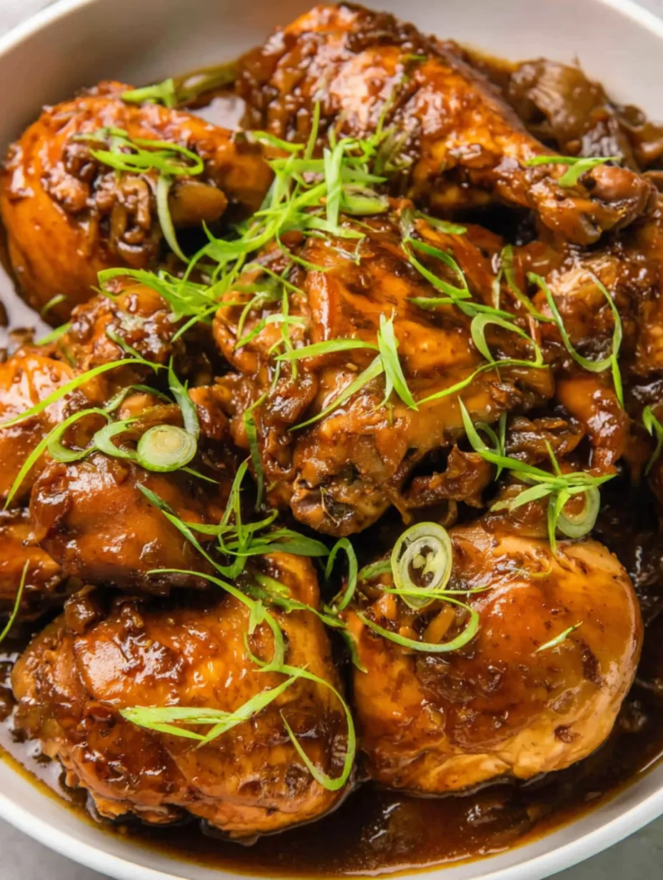 A close up of chicken with green onions and mushrooms.