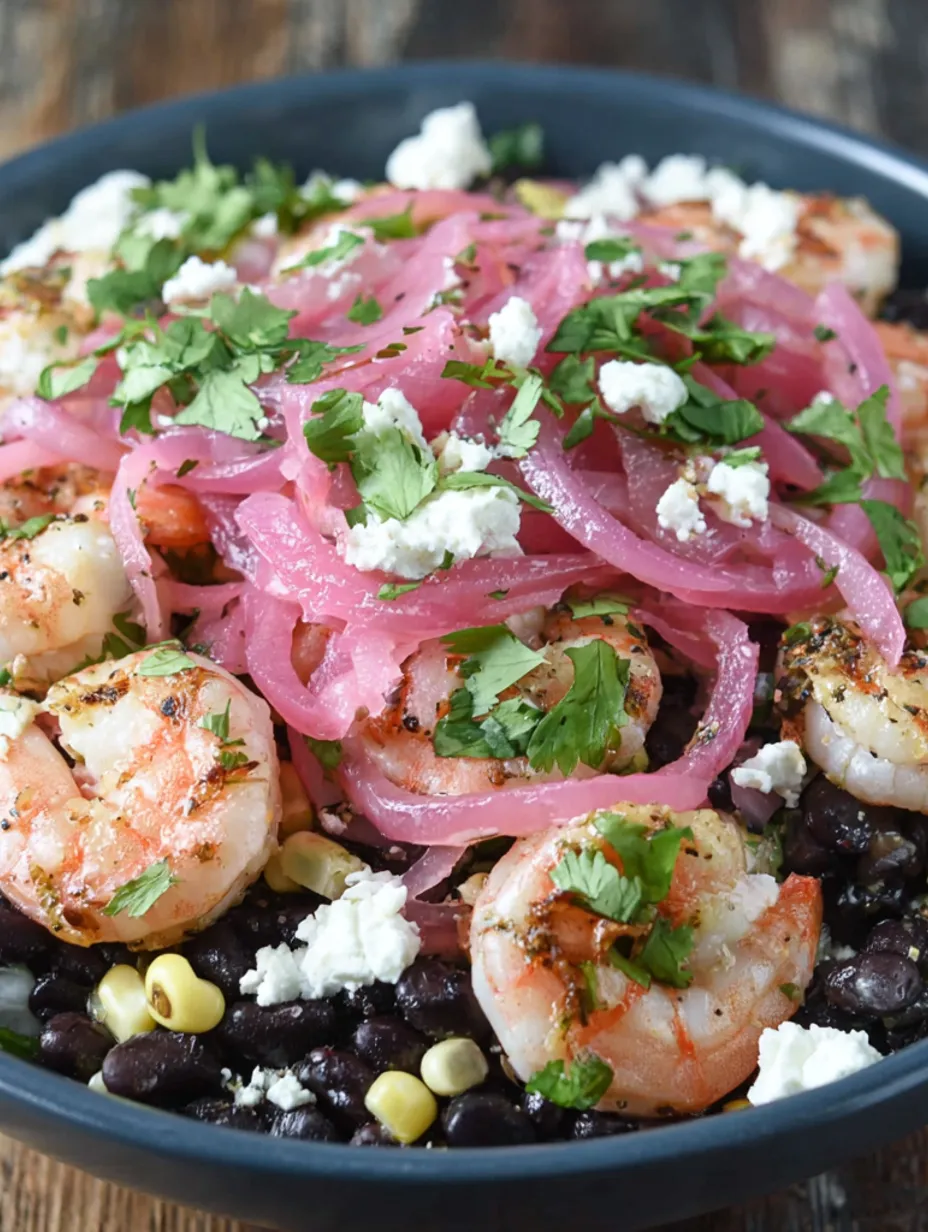 A dish of black bean shrimp salad with corn and pickled onions.