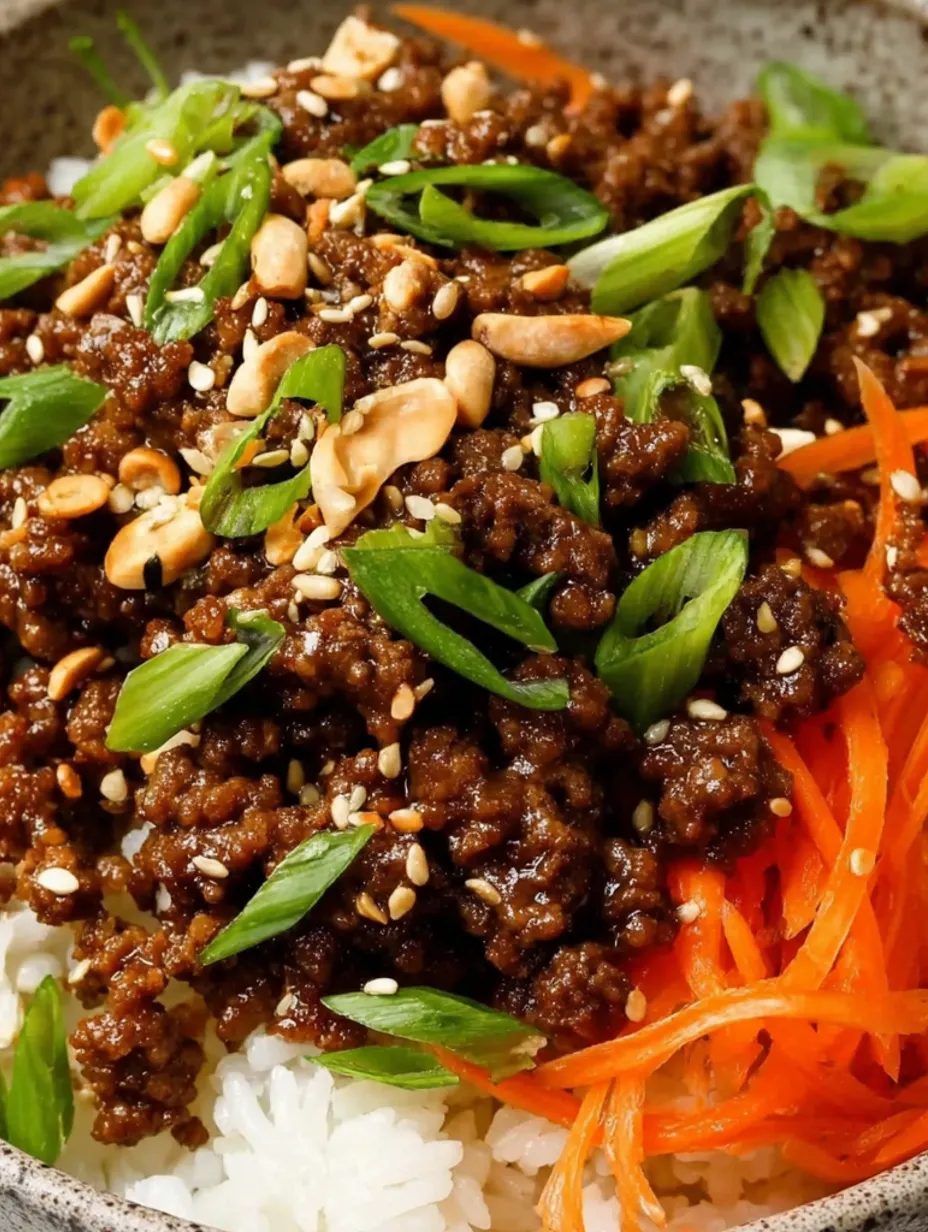 A bowl of beef with carrots and peanuts.