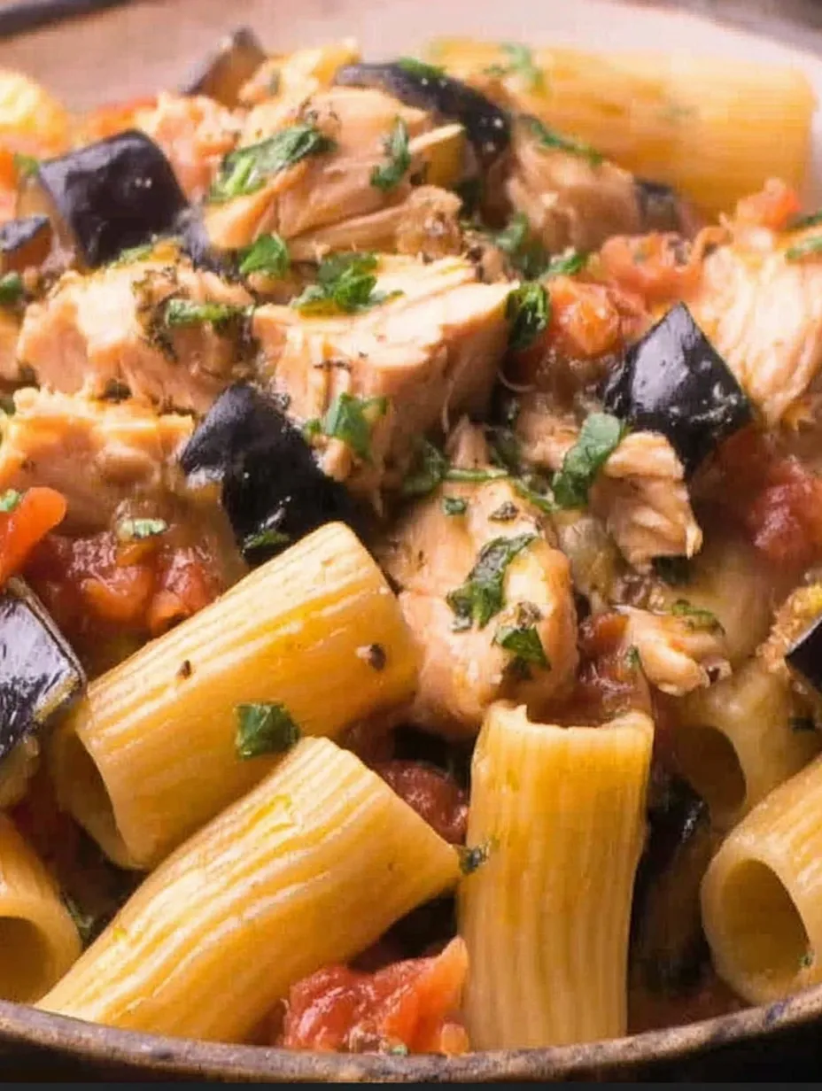 A dish of pasta with swordfish and black olives.