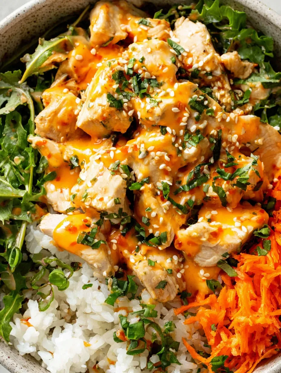 A spicy bang bang chicken bowl with rice and vegetables.