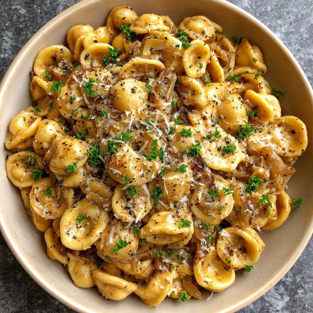 A bowl of pasta with cheese and herbs.