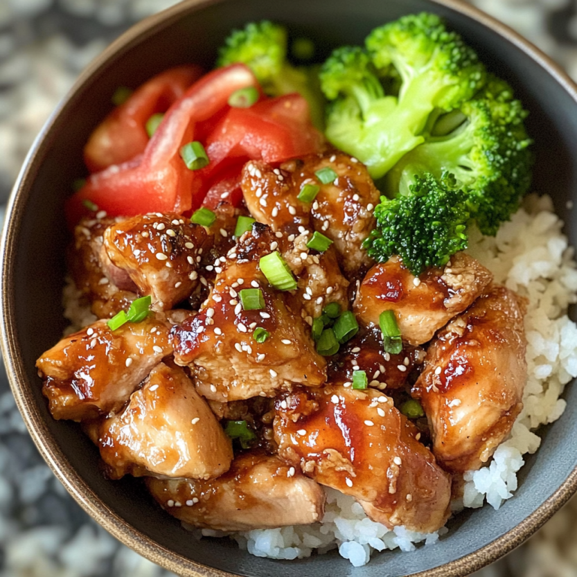 A bowl of food with chicken and broccoli.