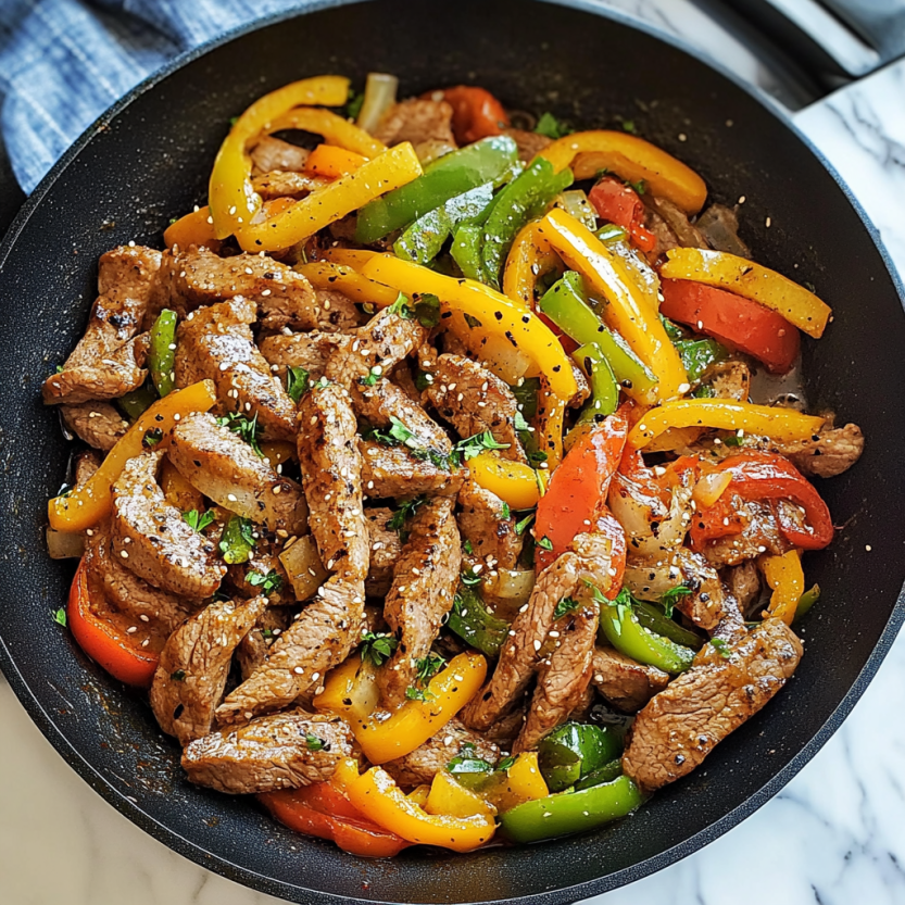 A skillet filled with peppers and meat.