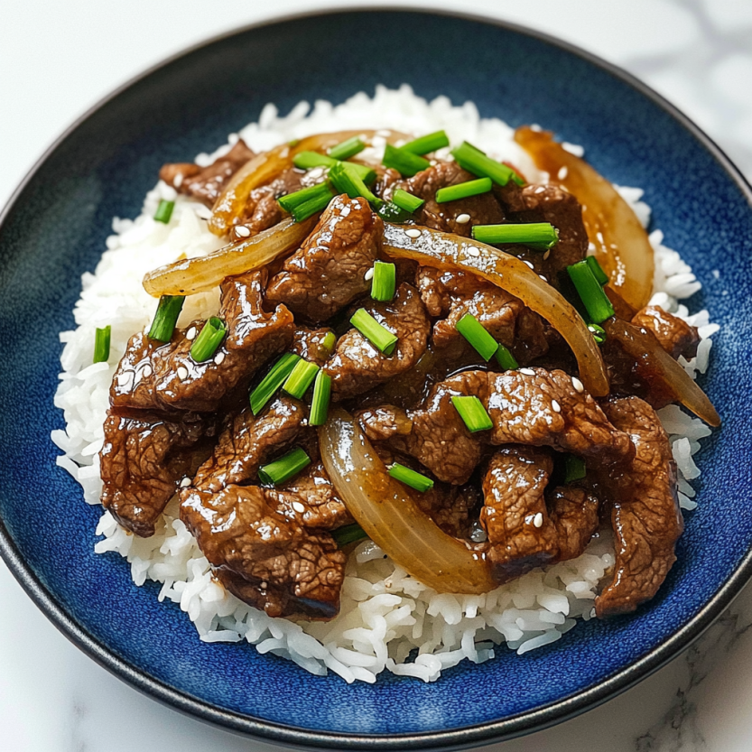 A plate of beef and onion stir fry.