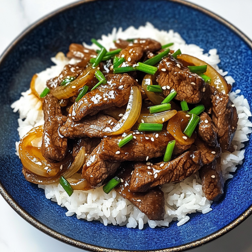A plate of beef and onion stir fry.