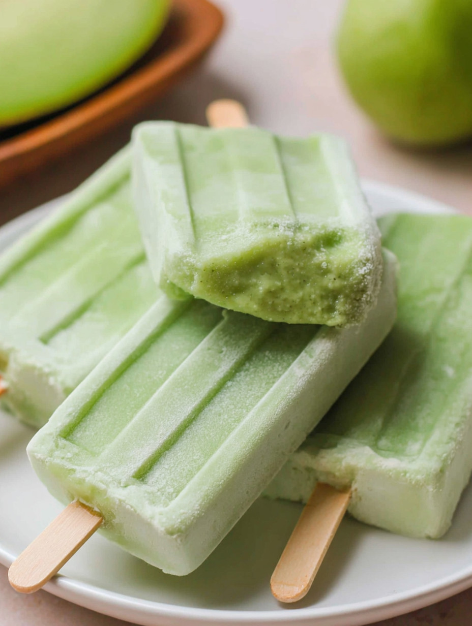 Green melon bars on a white plate.