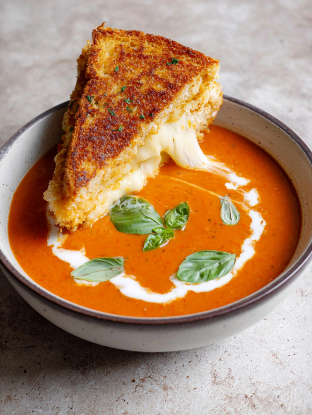 A bowl of soup with a slice of cheese toastie in it.