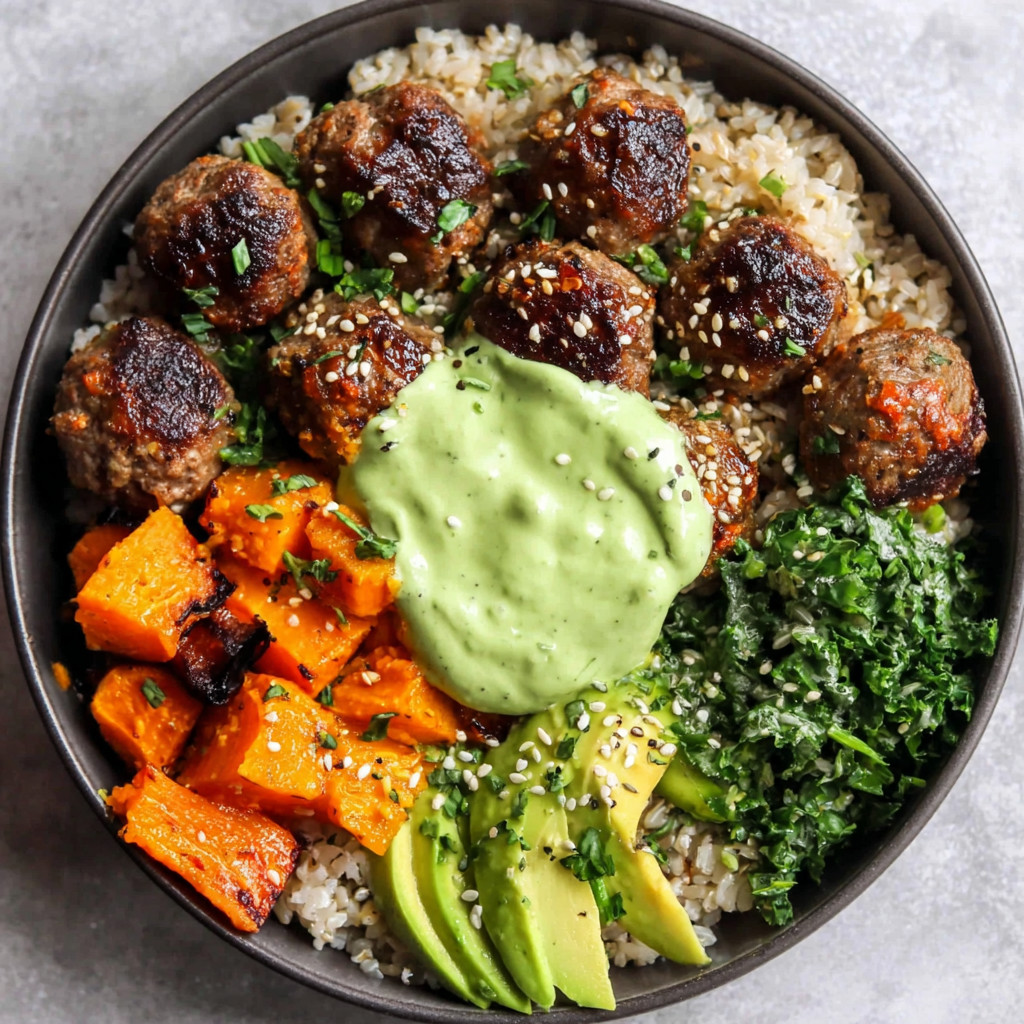 A bowl of meatballs with rice and avocado sauce.