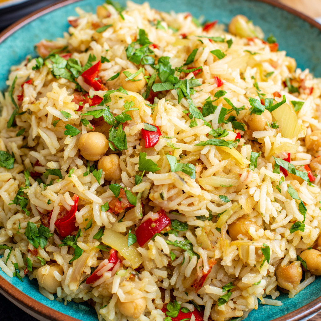 A bowl of rice with chickpeas and vegetables.