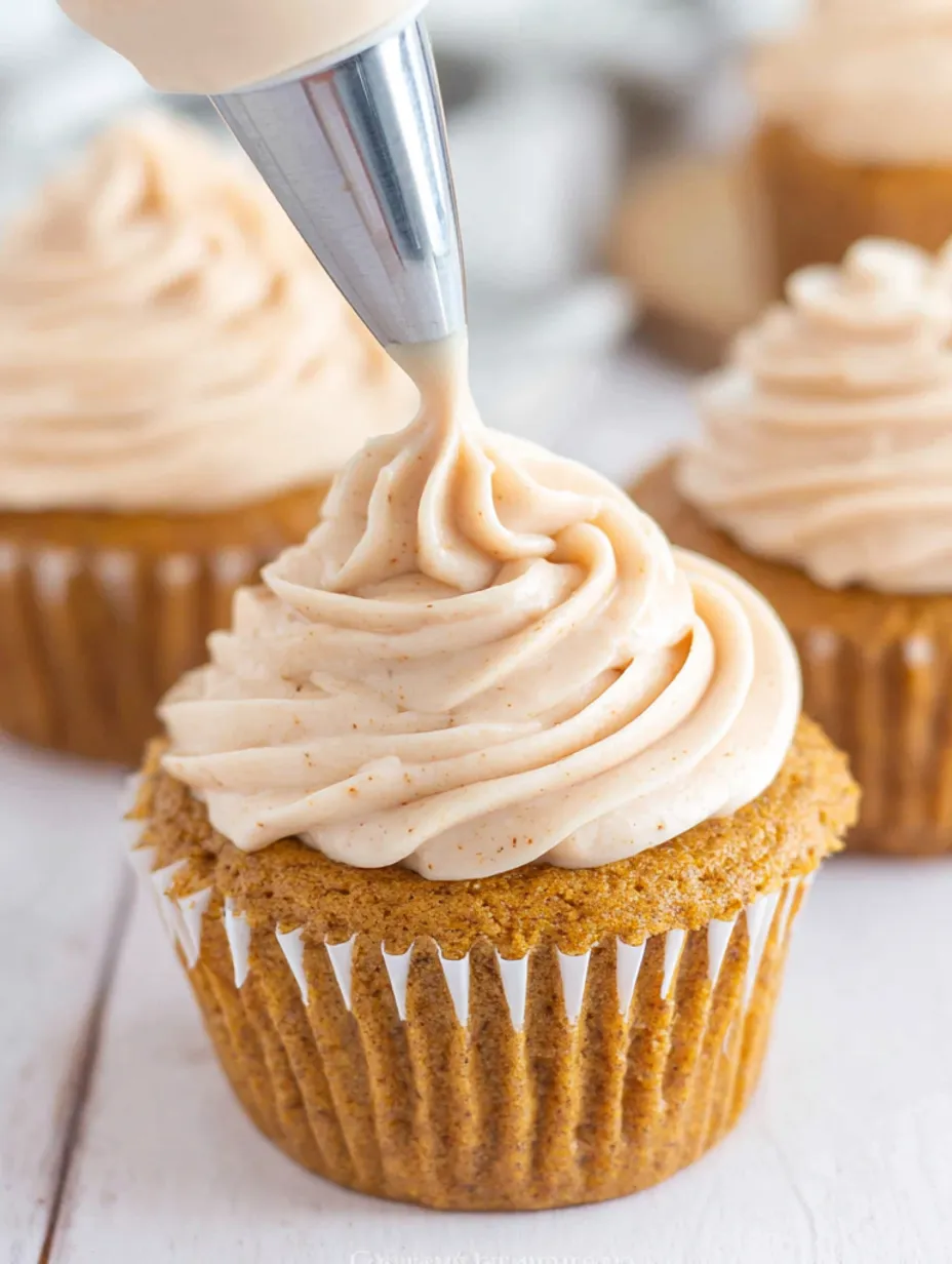 A cupcake with a dollop of frosting on top.