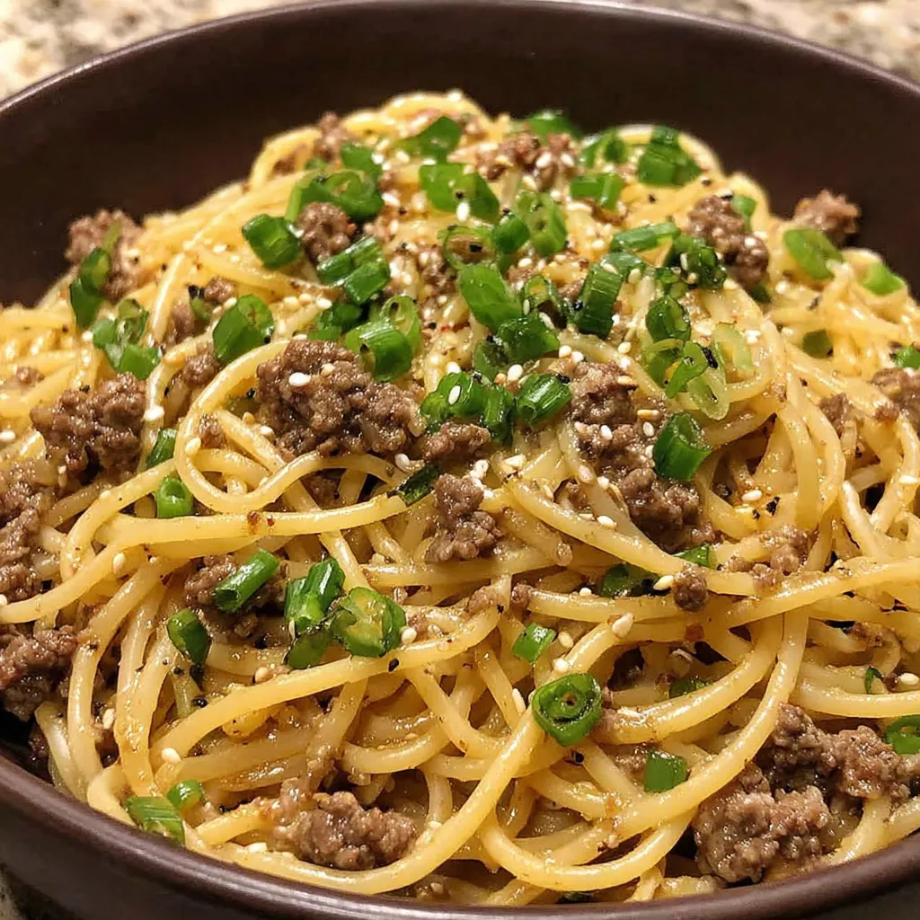 A bowl of noodles with meat and vegetables.