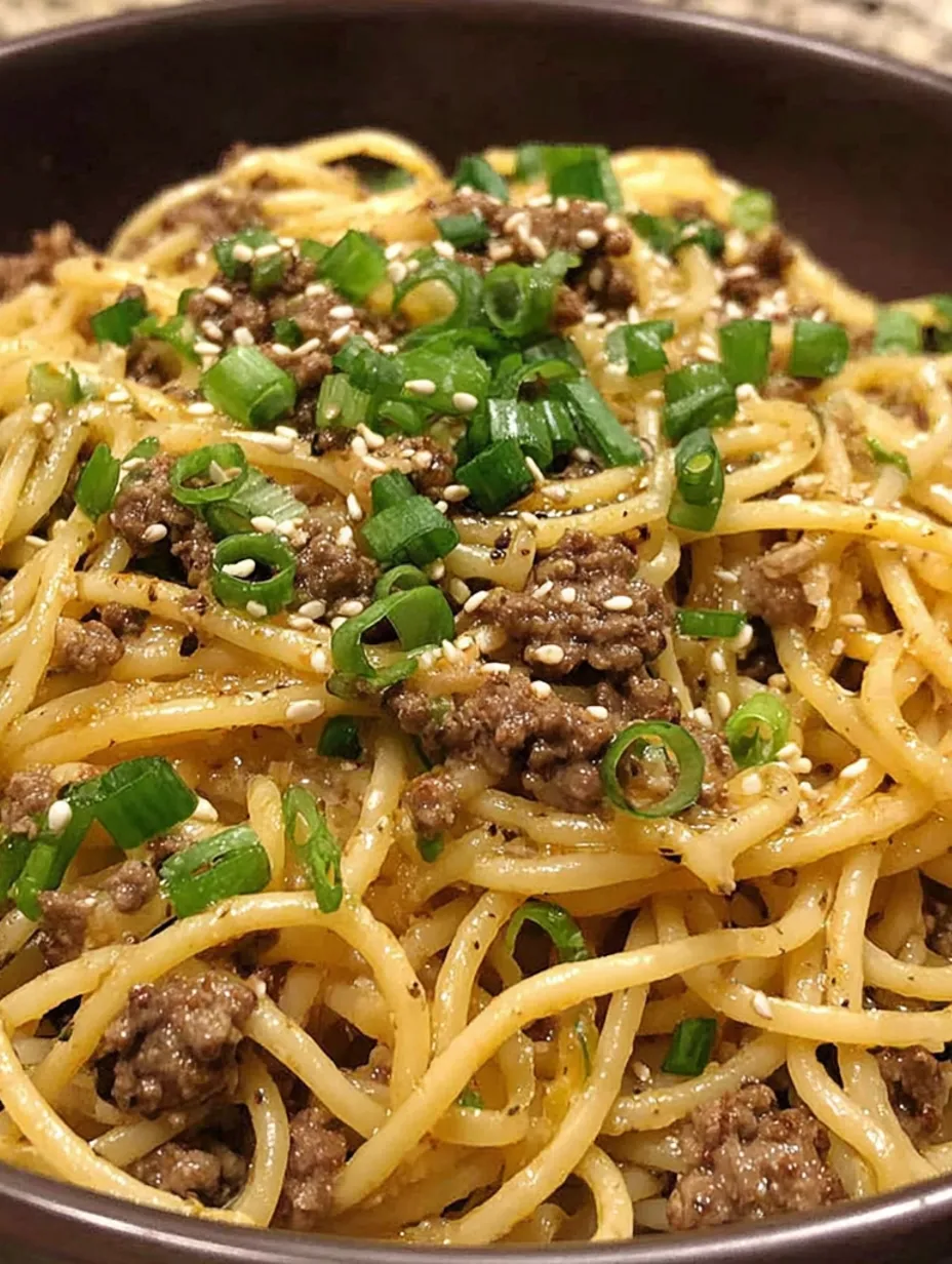 A plate of noodles with meat and vegetables.