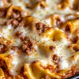 A close up of a bowtie casserole with meat and cheese.